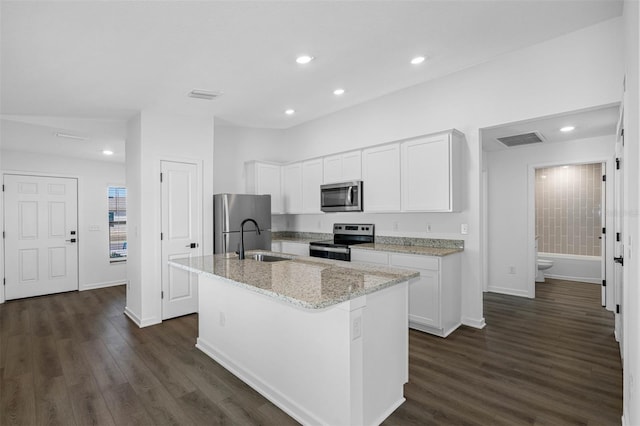 kitchen featuring white cabinetry, a center island with sink, dark hardwood / wood-style flooring, appliances with stainless steel finishes, and sink