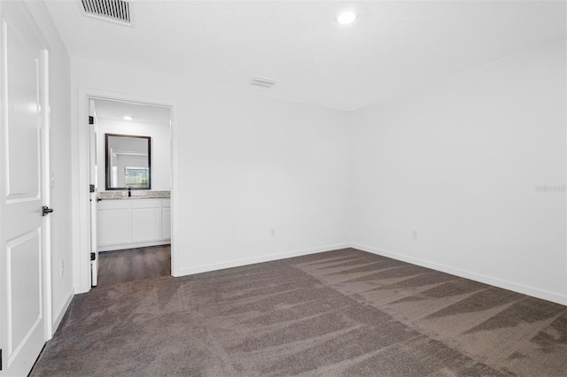 unfurnished room with dark colored carpet and sink