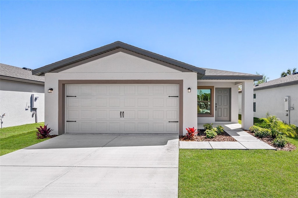 single story home featuring a garage and a front lawn