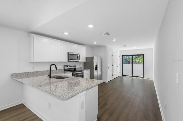 kitchen featuring sink, stainless steel appliances, white cabinets, dark hardwood / wood-style flooring, and kitchen peninsula