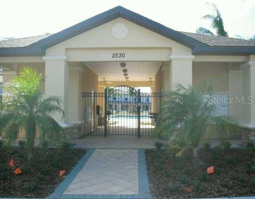 entrance to property featuring a gate and stucco siding