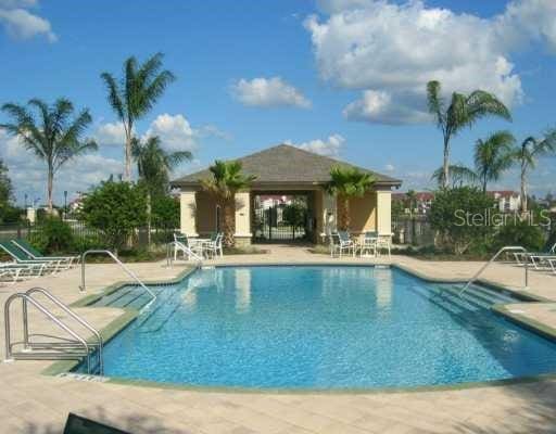 community pool with fence and a patio