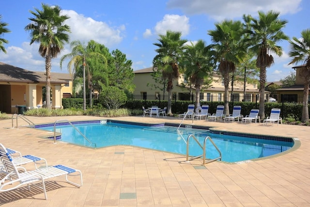 community pool featuring a patio area and fence