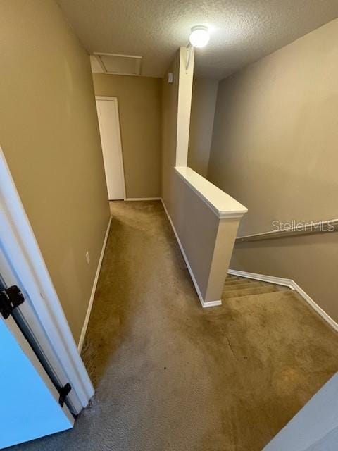 hall featuring a textured ceiling and carpet