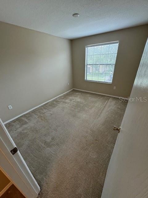 carpeted empty room with a textured ceiling