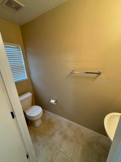 bathroom with tile patterned flooring and toilet