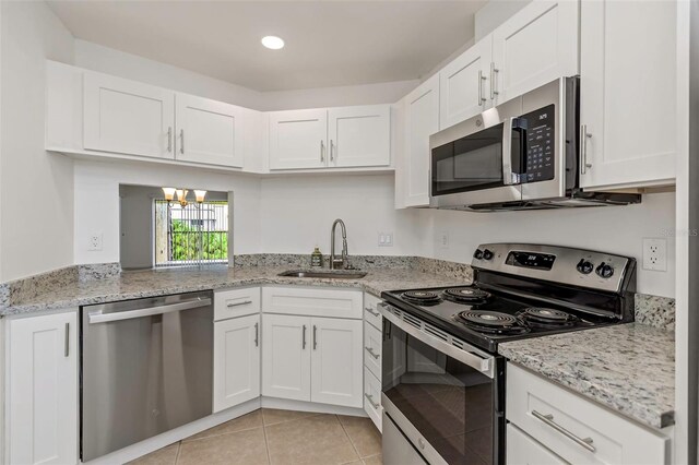 kitchen featuring sink, appliances with stainless steel finishes, white cabinets, and light tile patterned floors