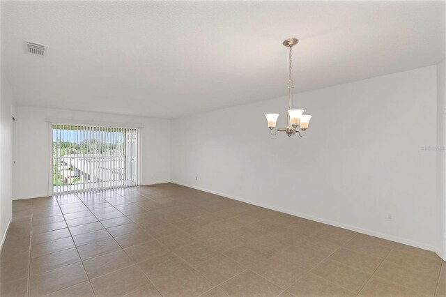 unfurnished room featuring light tile patterned flooring and a notable chandelier