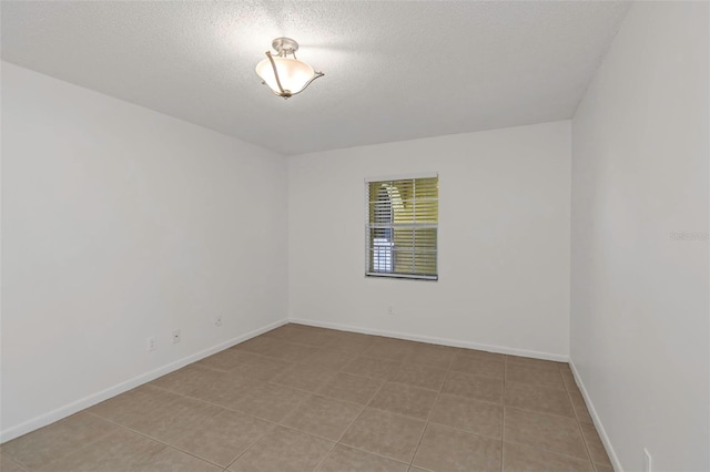 tiled spare room with a textured ceiling