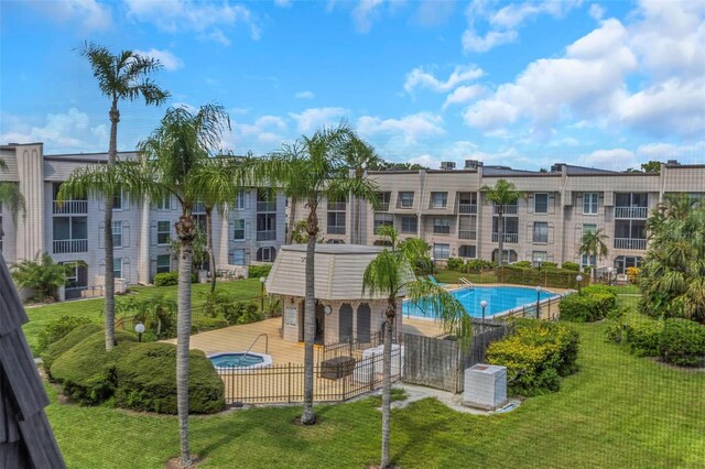 view of pool with central AC unit and a lawn