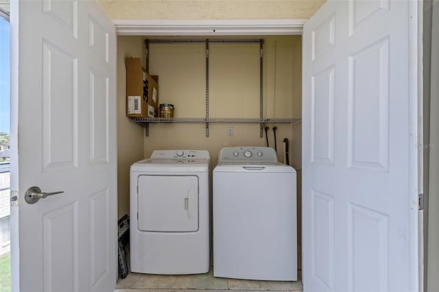 laundry area featuring washer and dryer and light tile patterned floors