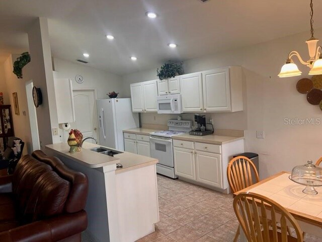 kitchen with decorative light fixtures, light tile patterned floors, white appliances, lofted ceiling, and kitchen peninsula