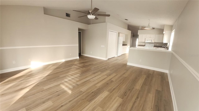 unfurnished living room with ceiling fan, high vaulted ceiling, and light wood-type flooring