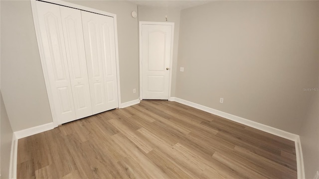 unfurnished bedroom featuring light hardwood / wood-style flooring and a closet