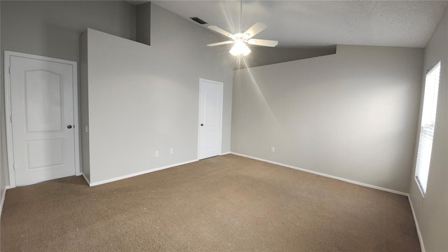 carpeted spare room with a textured ceiling, ceiling fan, and lofted ceiling