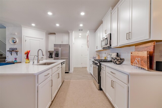 kitchen with light wood-type flooring, white cabinets, an island with sink, stainless steel appliances, and sink