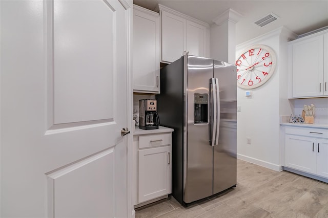 kitchen with stainless steel fridge with ice dispenser, light hardwood / wood-style flooring, and white cabinets