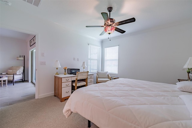 carpeted bedroom with ornamental molding and ceiling fan