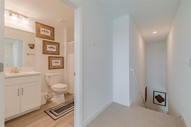 bathroom featuring vanity, toilet, and hardwood / wood-style flooring