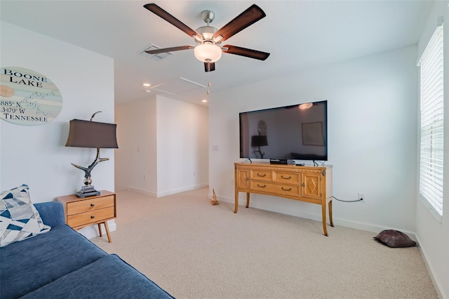 living room with ceiling fan, a healthy amount of sunlight, and light colored carpet