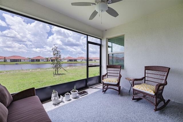 sunroom / solarium featuring plenty of natural light, a water view, and ceiling fan