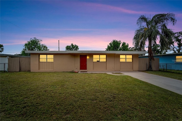 ranch-style home featuring a lawn