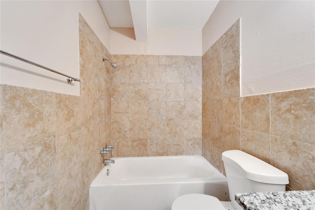 full bathroom featuring tiled shower / bath, tile walls, and toilet