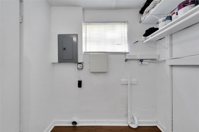 laundry room with hardwood / wood-style flooring and electric panel