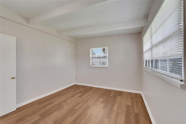 unfurnished room with beam ceiling and hardwood / wood-style floors