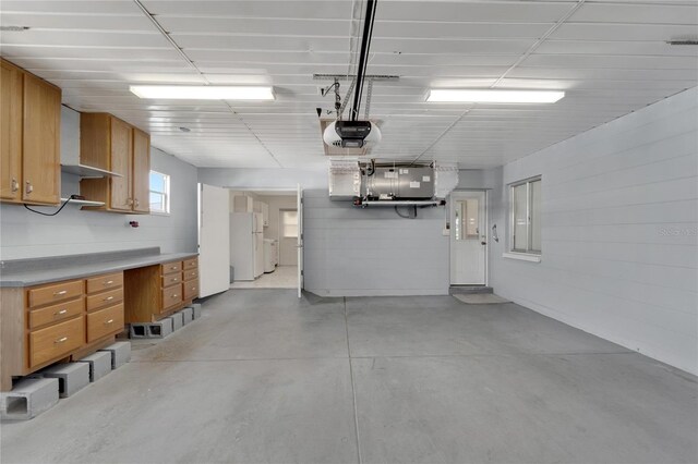 garage featuring white fridge and a garage door opener