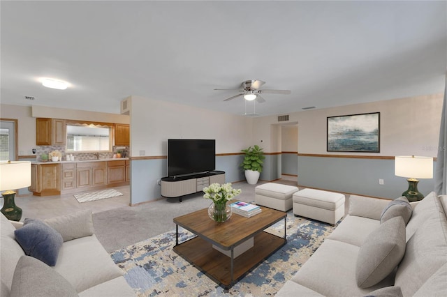 carpeted living room featuring ceiling fan