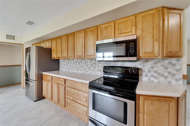 kitchen featuring tasteful backsplash, light brown cabinetry, and stainless steel appliances