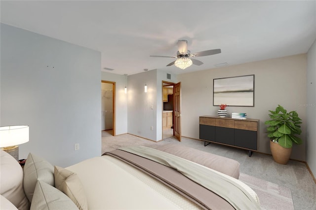 bedroom featuring a closet, a walk in closet, light carpet, and ceiling fan