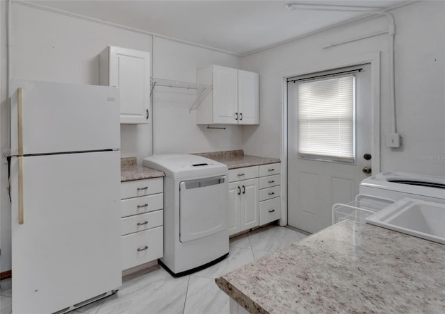 kitchen with white cabinets, washer / dryer, sink, and white refrigerator