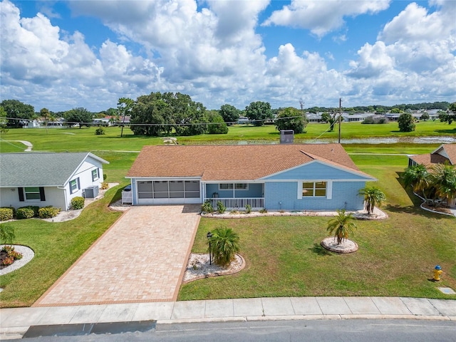 609 Fox Hills Dr, Sun City Center, FL 33573 - ranch-style home featuring driveway, an attached garage, central air condition unit, a front lawn, and covered porch