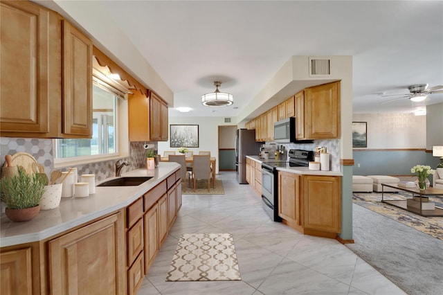 kitchen with light colored carpet, sink, ceiling fan, backsplash, and appliances with stainless steel finishes