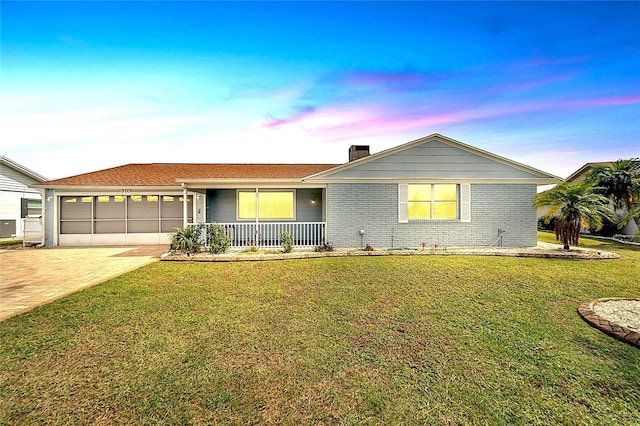 609 Fox Hills Dr, Sun City Center, FL 33573 - ranch-style home featuring covered porch, a garage, driveway, a yard, and a chimney