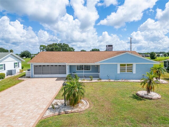 609 Fox Hills Dr, Sun City Center, FL 33573 - single story home featuring cooling unit, driveway, covered porch, an attached garage, and a front yard