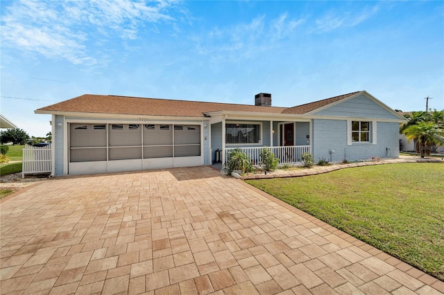 609 Fox Hills Dr, Sun City Center, FL 33573 - single story home featuring covered porch, decorative driveway, a front lawn, an attached garage, and a chimney