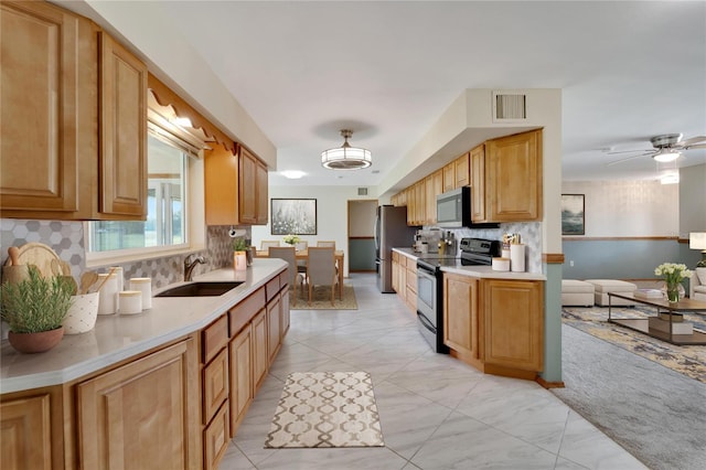 609 Fox Hills Dr, Sun City Center, FL 33573 - kitchen featuring stainless steel appliances, a sink, light countertops, decorative backsplash, and a ceiling fan