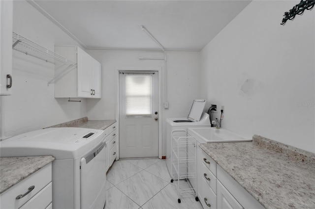 609 Fox Hills Dr, Sun City Center, FL 33573 - laundry area featuring washing machine and dryer, cabinet space, and light marble finish floors
