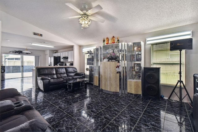 tiled living room featuring a textured ceiling, ceiling fan, and lofted ceiling