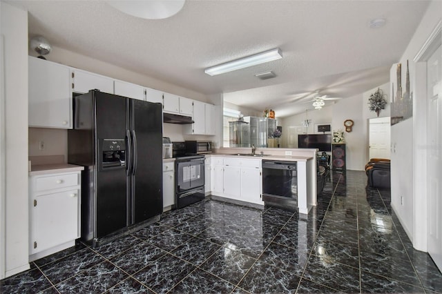 kitchen with black appliances, white cabinets, sink, vaulted ceiling, and dark tile patterned flooring