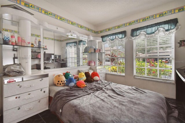 tiled bedroom with a textured ceiling