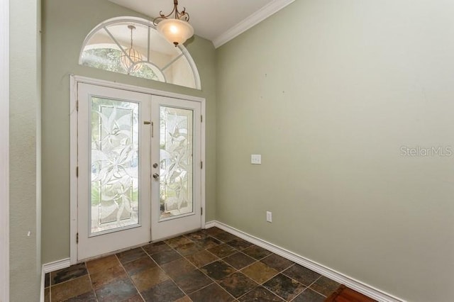 entryway with dark tile patterned floors, a wealth of natural light, french doors, and crown molding