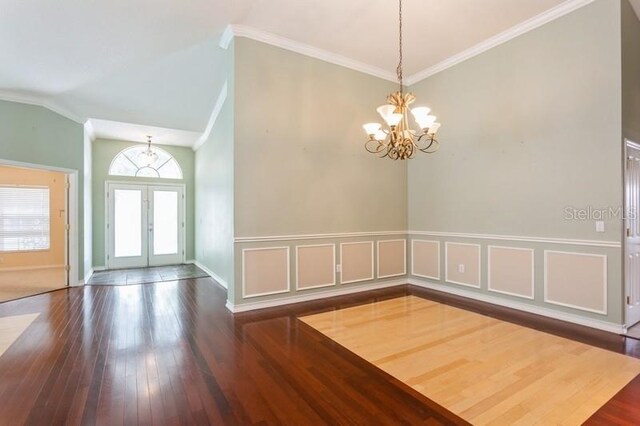 interior space with vaulted ceiling, crown molding, wood-type flooring, and a notable chandelier