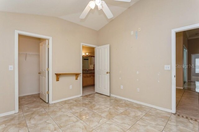 unfurnished bedroom with a closet, a spacious closet, ceiling fan, lofted ceiling, and light tile patterned floors