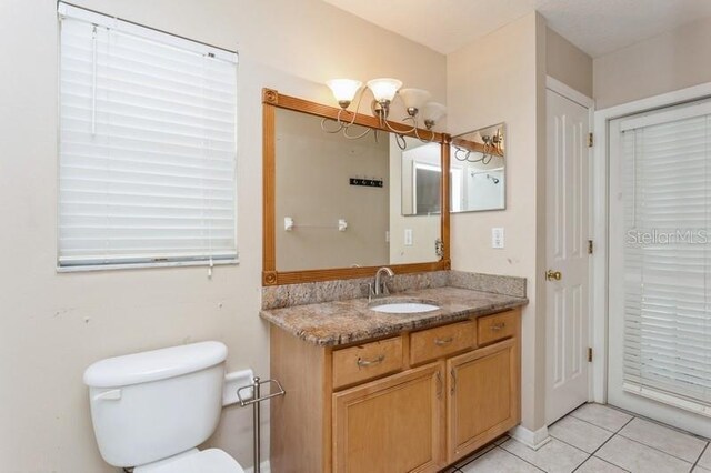 bathroom featuring vanity, tile patterned flooring, and toilet