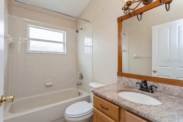 full bathroom with tiled shower / bath combo, toilet, and vanity