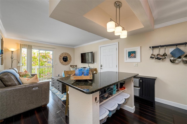 kitchen with crown molding, a breakfast bar, dark wood-type flooring, and pendant lighting